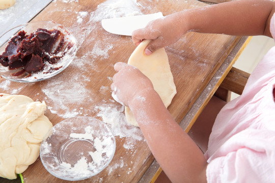 小孩子在学习制作面食糕点