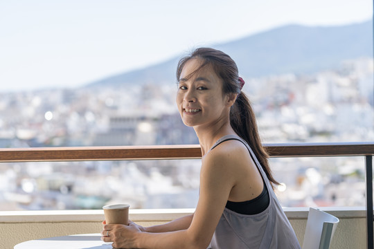 穿着运动服的亚洲女性坐在阳台上