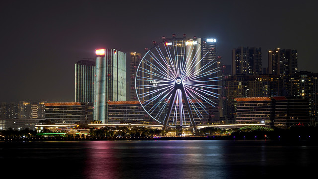 夜晚摩天轮转动滨海建筑欢乐港湾