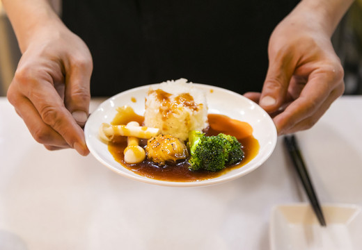 用手端着的鲍鱼饭