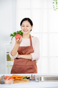 女主人在厨房手拿西红柿摆拍