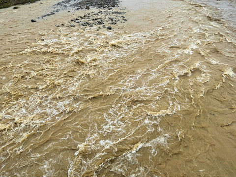 暴雨后浑黄湍急的河水
