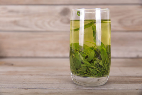 木质桌子上一杯刚泡好的绿茶