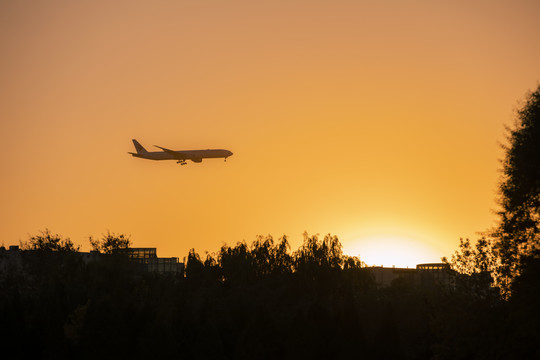 夕阳下飞机飞过天空