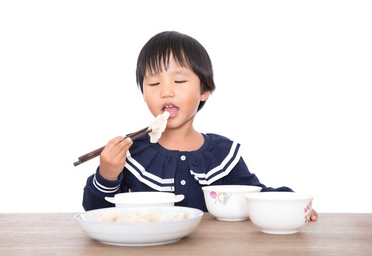 餐桌前中国小女孩在自己吃饭