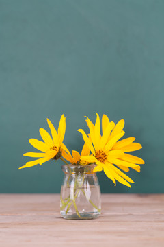 黑板前的桌子上一簇黄色的野花