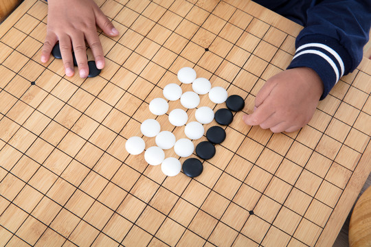 小孩子在棋盘上学习下围棋