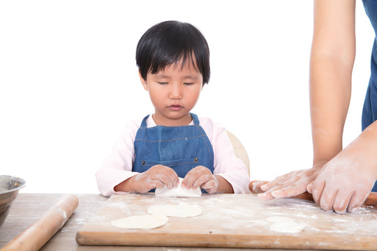 小女孩认真的学习包饺子