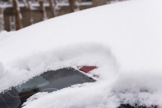汽车上大雪之后堆积的厚厚雪花