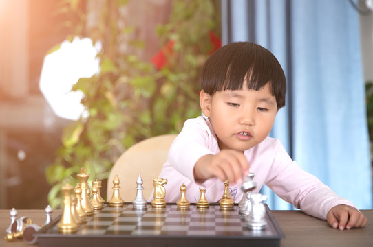 小女孩在学习下国际象棋