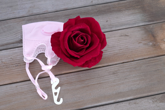 红色玫瑰花朵和N95口罩