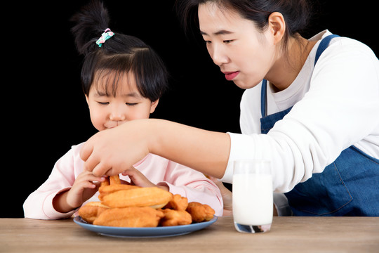 中国妈妈在喂女儿吃油条