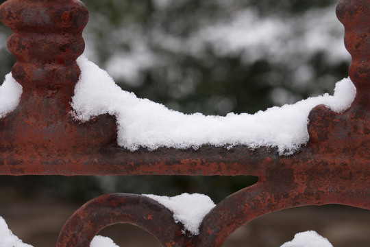 金属栅栏上堆积着洁净的白雪