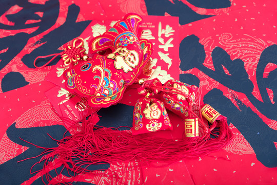 红色春联背景上的鱼形挂饰和红包
