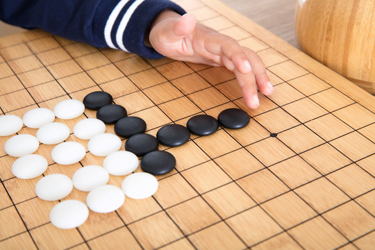 小孩子在棋盘上学习下围棋