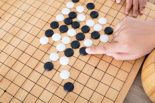 手指导着小孩的手下围棋