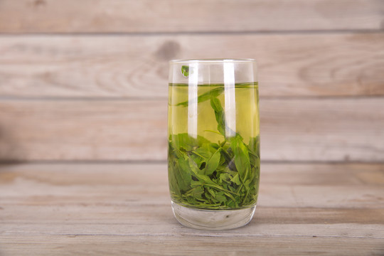 木质桌子上一杯刚泡好的绿茶