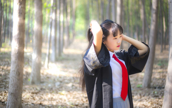 树林里穿着学士服的女孩