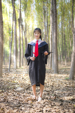 树林里穿着学士服的女孩