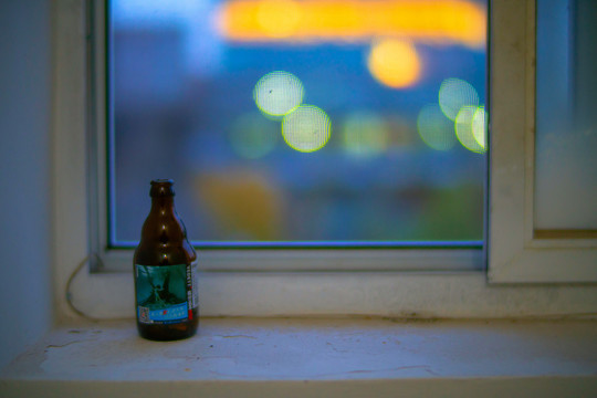 黎明楼道窗口的空啤酒瓶和窗外的