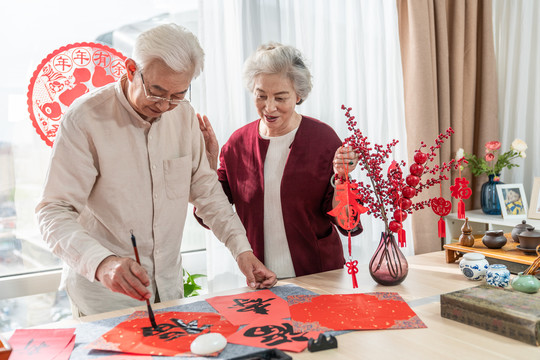 快乐的老年夫妻在家写毛笔字