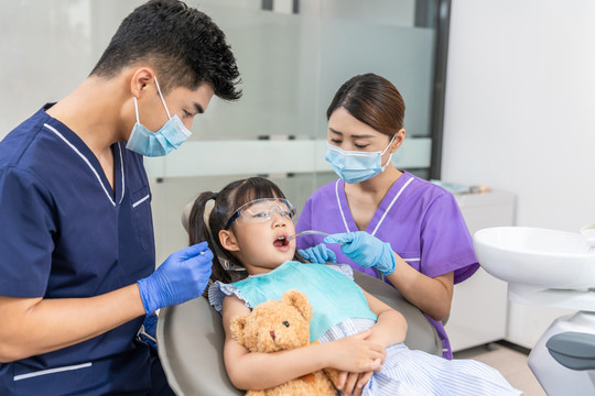 牙科医生给小女孩治疗