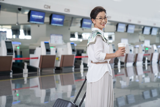老年女人在机场拿着咖啡