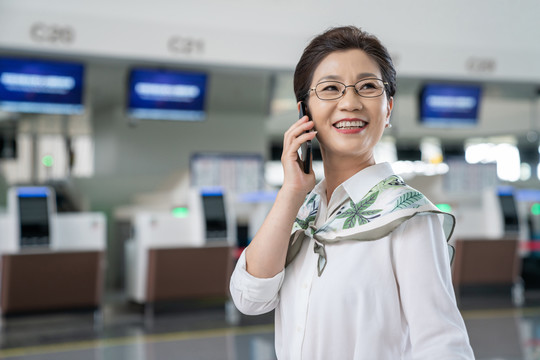 老年女人在机场打电话