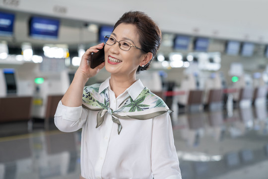 老年女人在机场打电话