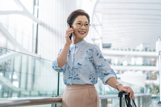 老年女人在机场打电话