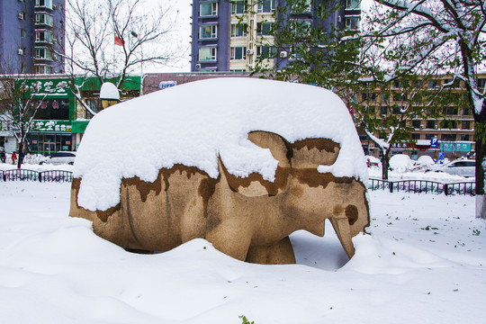 石雕大象与树木枝叶雪挂雪景