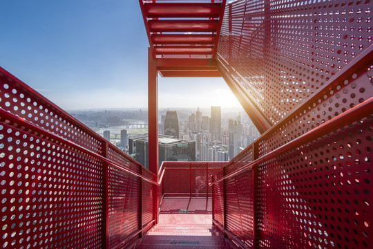 摩天大楼红色钢结构楼梯和城市景