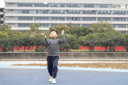 操场上打羽毛球的小男孩