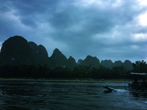 绵延的山峰和溪水游船风景图片