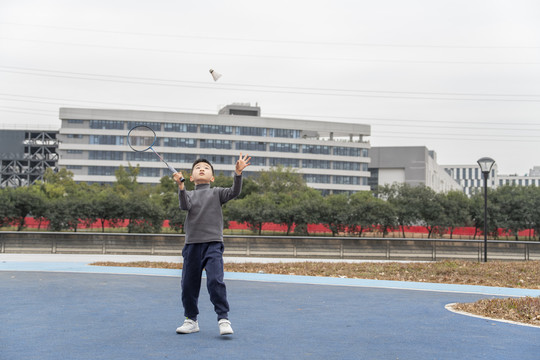 操场上打羽毛球的小男孩