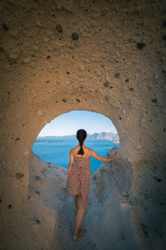 亚洲女性站在海岛悬崖山洞里