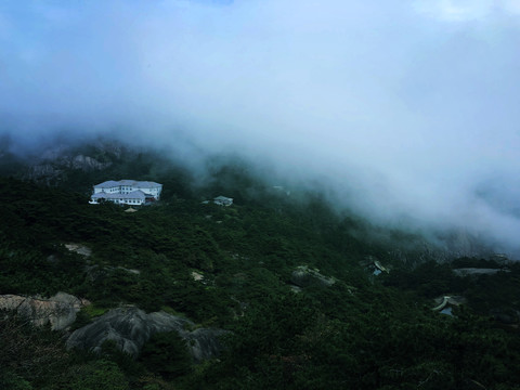 云雾缭绕下的山地建筑风景图