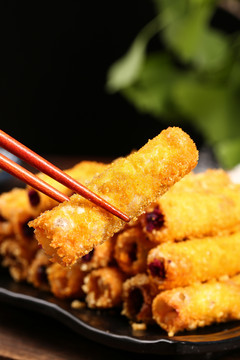 筷子上夹着油炸紫薯卷