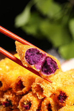 筷子上夹着紫薯卷