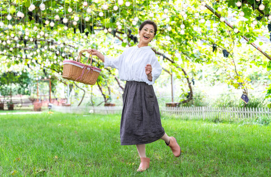 老年女人在果园采摘葡萄