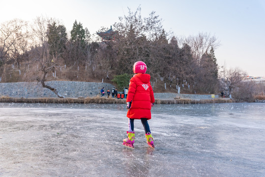 红衣服的小女孩在湖面滑冰
