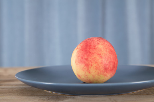 一个新鲜的桃子在盘子里