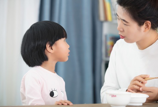 年轻妈妈喂女儿吃饭