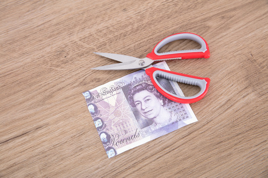 剪刀和剪断的英镑钞票