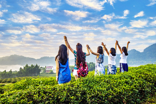 面向大山举起手臂的一群女人