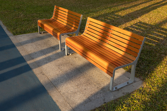 夕阳中橙黄色的公园木质长椅