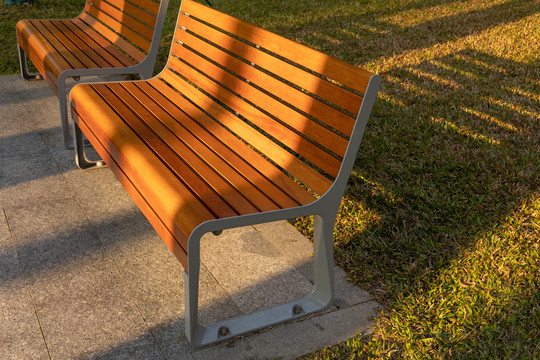 夕阳中橙黄色的公园木质长椅