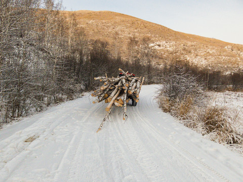 冬季山路积雪拉木材