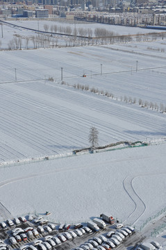 雪后的高楼田野和汽车