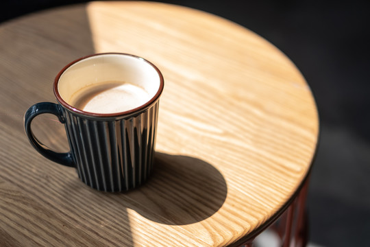 咖啡杯光影和原木色桌面